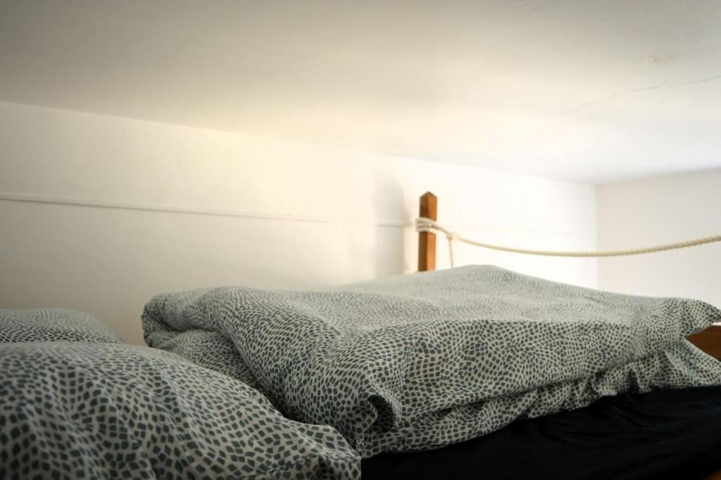 a bedroom with a bed with a comforter on it at Le Joffre - studio sur la digue en centre ville in Arromanches-les-Bains
