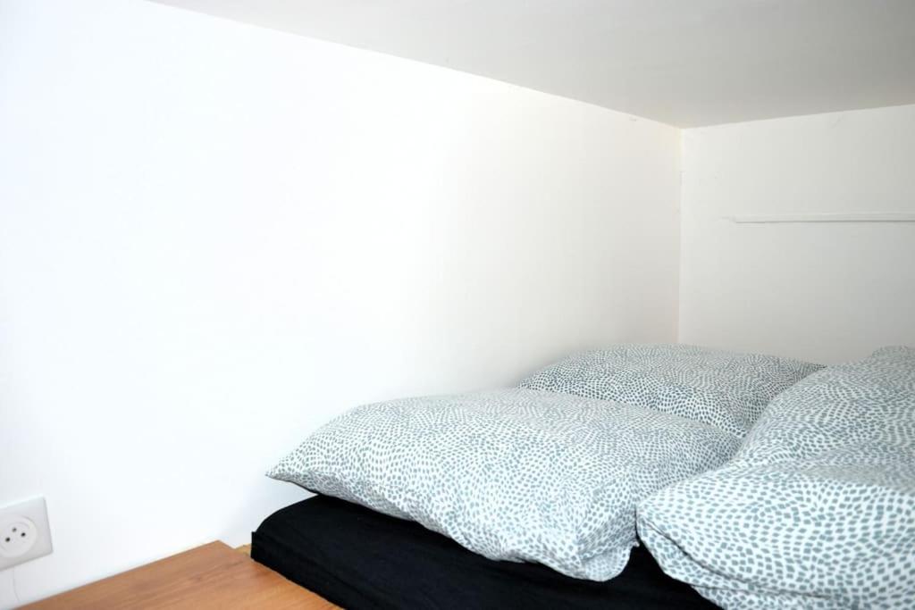a bedroom with a bed with two pillows on it at Le Joffre - studio sur la digue en centre ville in Arromanches-les-Bains