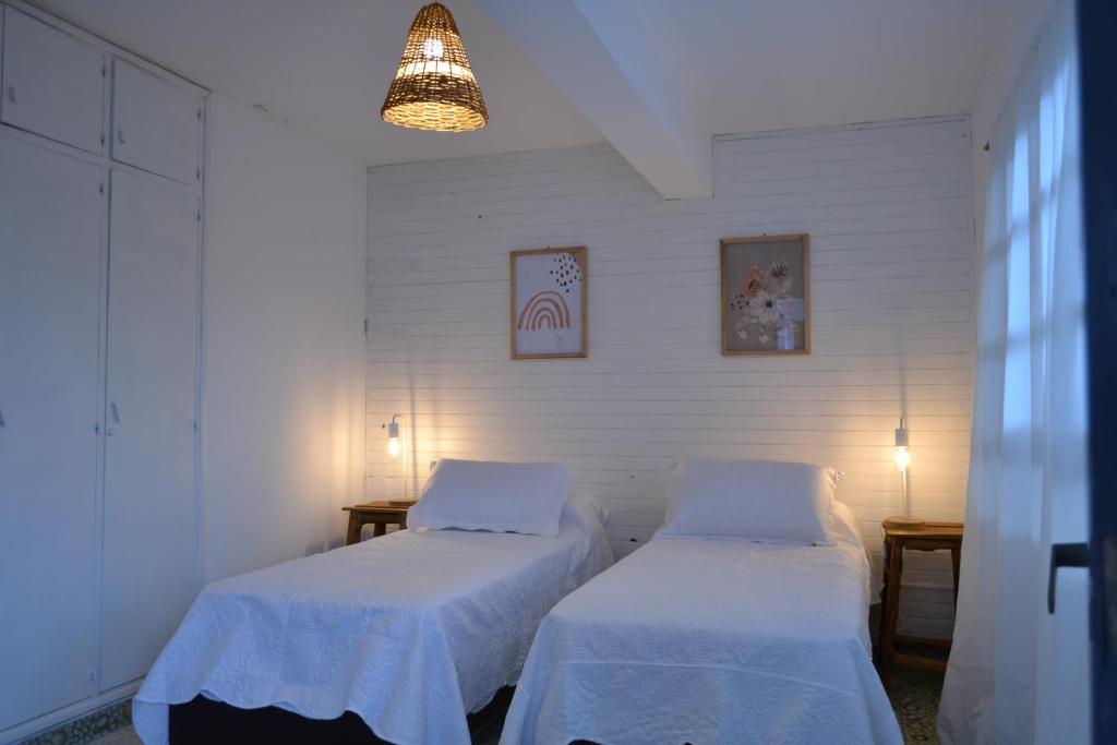 Duas camas num quarto com paredes brancas em El Pensamiento Jujuy em San Salvador de Jujuy