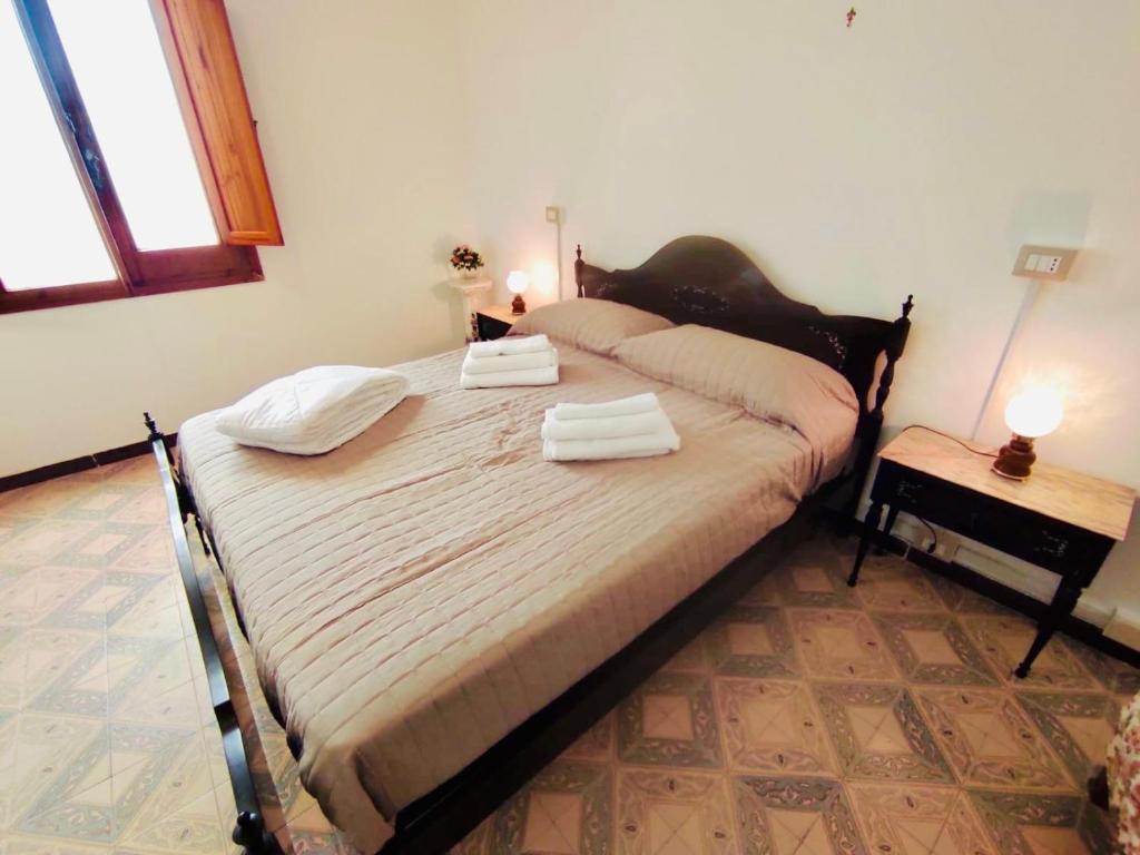 1 dormitorio con 1 cama grande y toallas. en Residenza Tata Annita, en Sorso