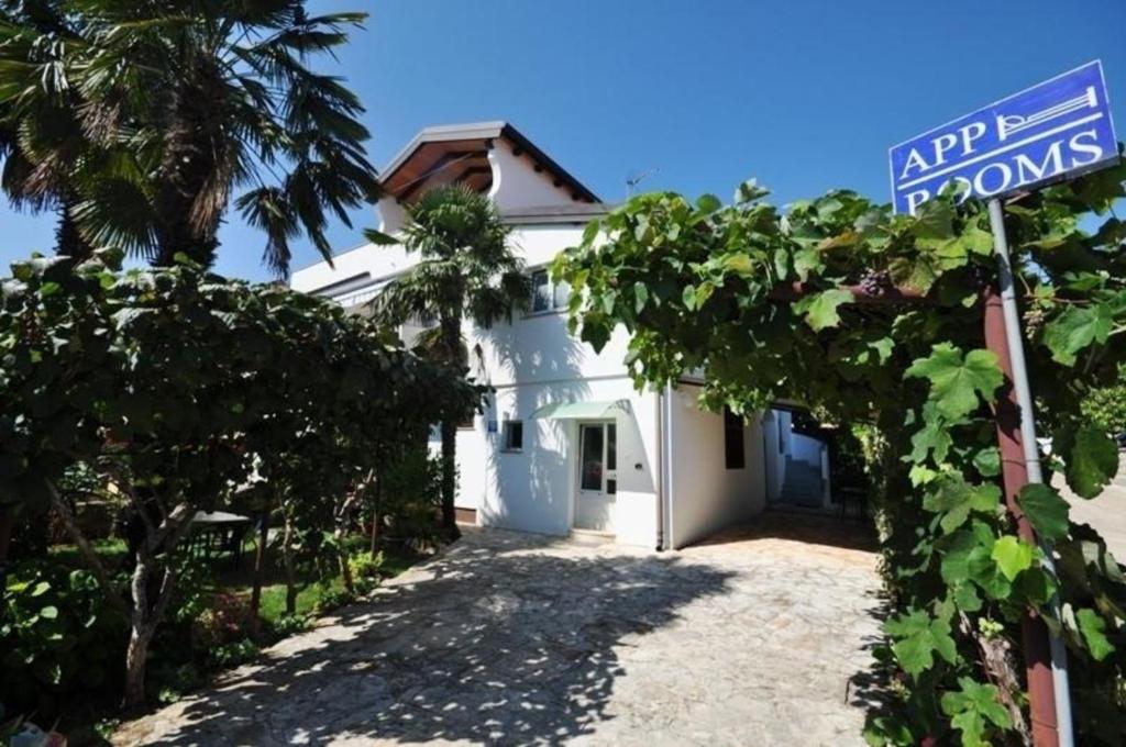 a white house with a street sign in front of it at Wohnung in Novigrad mit privatem Parkplatz in Karpinjan