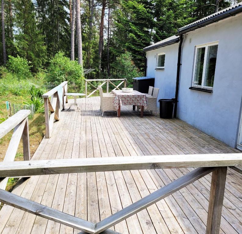 a wooden deck with a table and chairs on it at Nice holiday home at Gotlands most child-friendly beach outside Slite in Slite