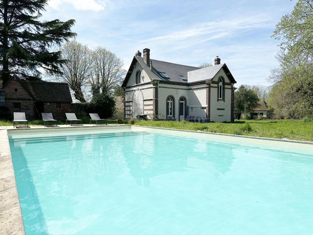 una gran piscina frente a una casa en L'Orangerie du Château - Heated swimming pool en Blandainville