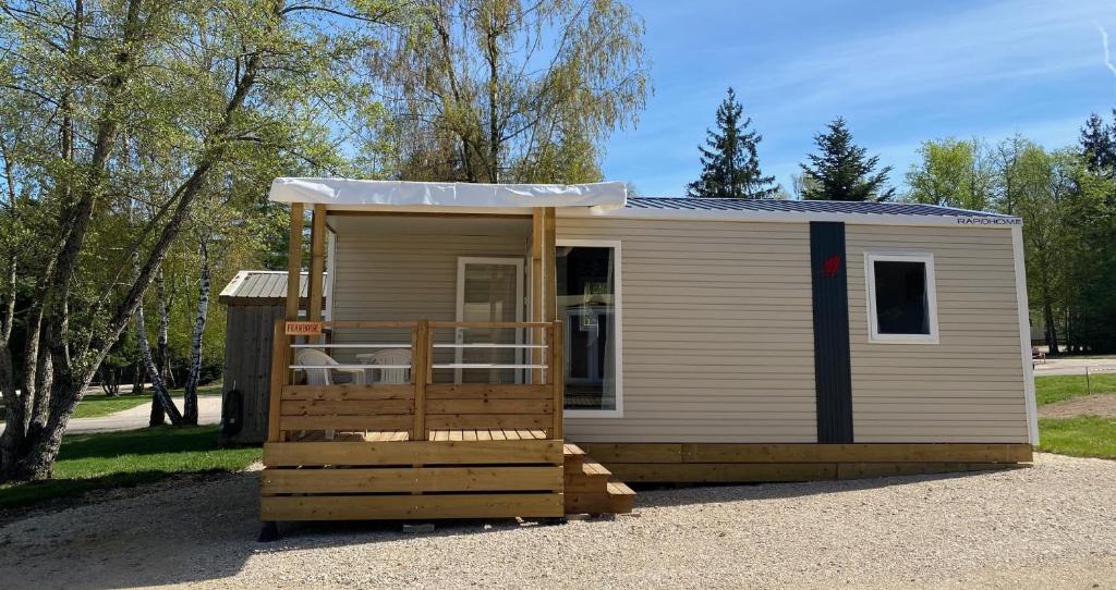 a tiny house with a porch and a roof at Camping Porte des Vosges in Bulgnéville