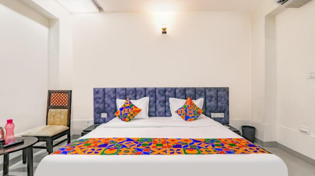 Un dormitorio con una cama grande y una silla. en HOTEL SILVER STONE INN, en Lucknow