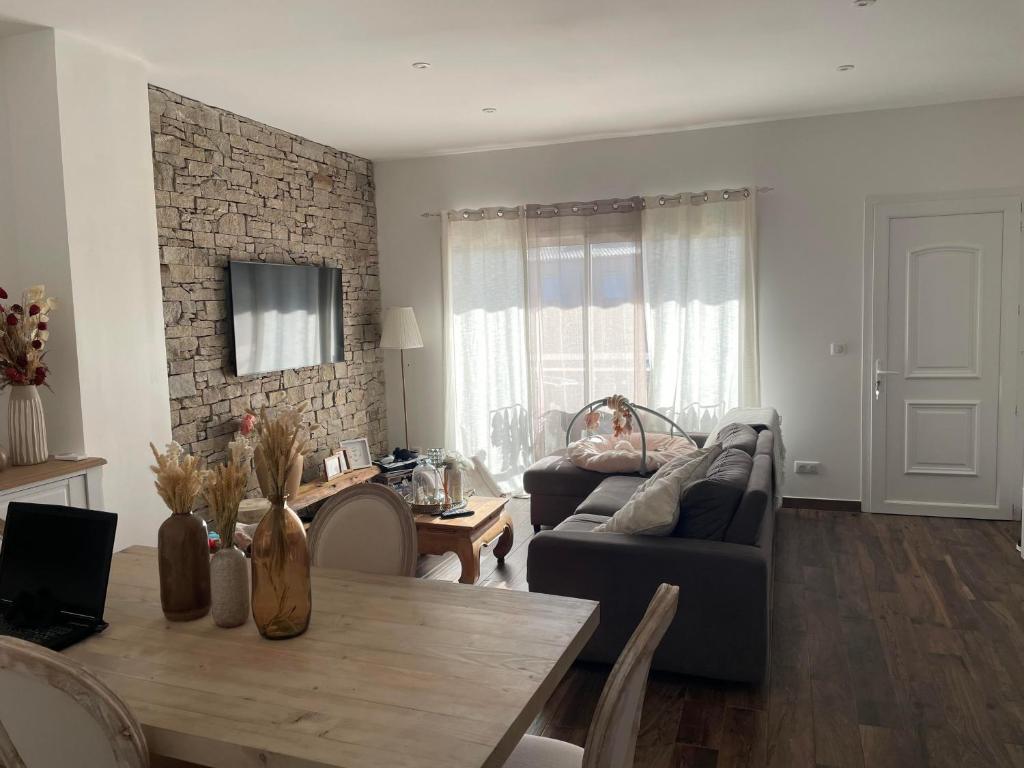 een woonkamer met een bank en een tafel bij Cosy Home in Ajaccio