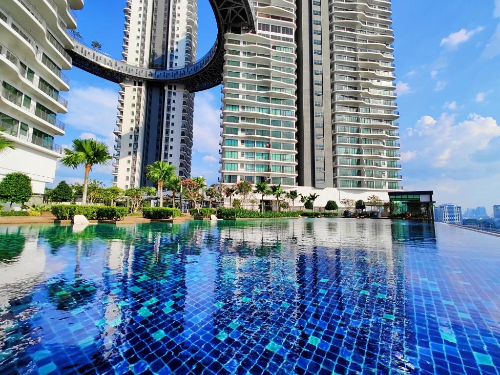 una piscina en medio de dos edificios altos en Kuala Lumpur Center 整套 Suites 无边泳池 Link LRT & MRT KLCC Mall, en Kuala Lumpur