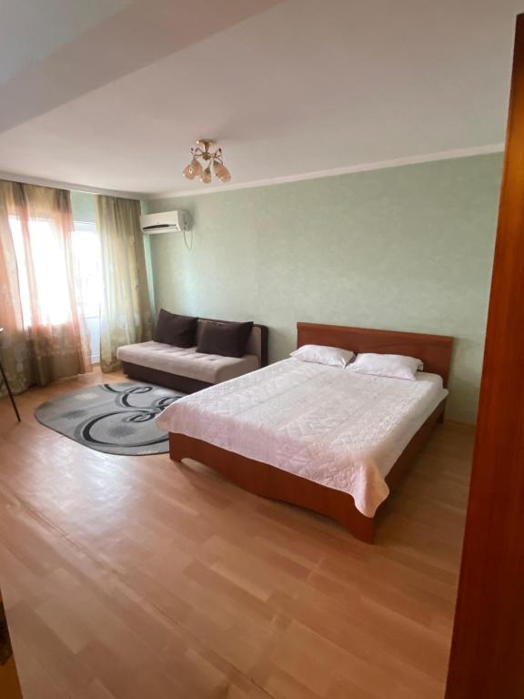 1 dormitorio con 1 cama y 1 sofá en Квартира на Сейфуллина, en Baljash