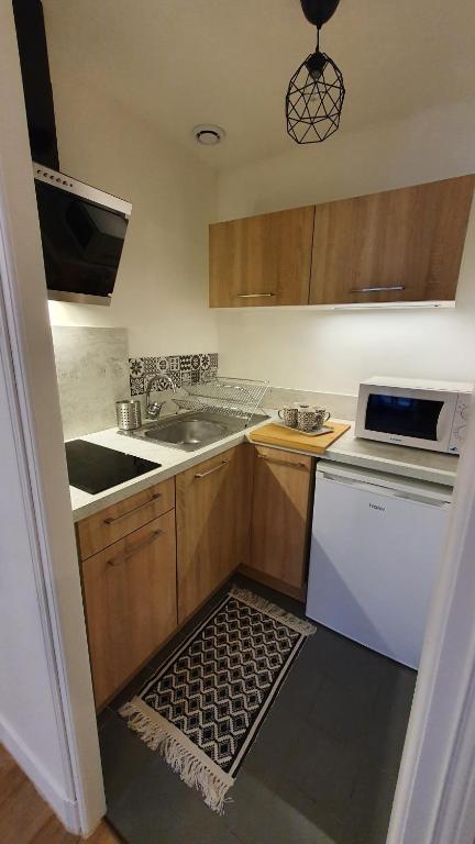 une cuisine avec un évier et une cuisinière dans l'établissement studio indépendant 2 personnes, à Auch