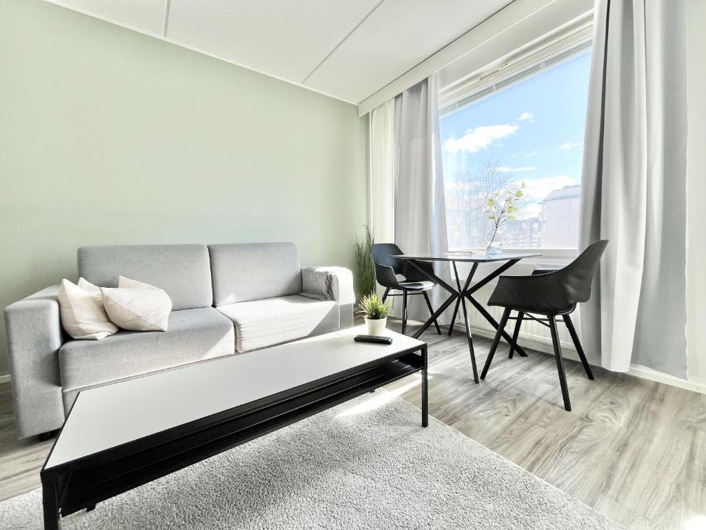 ein Wohnzimmer mit einem Sofa und einem Tisch in der Unterkunft Tammer Huoneistot - City Suite 1 - Sauna, Balcony & Free parking in Tampere