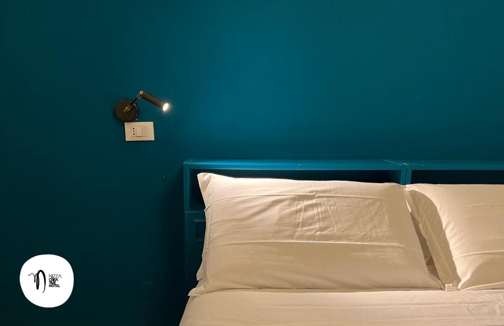 a blue bedroom with a bed with a blue wall at Hotel Nizza Creative Hotel in Rimini