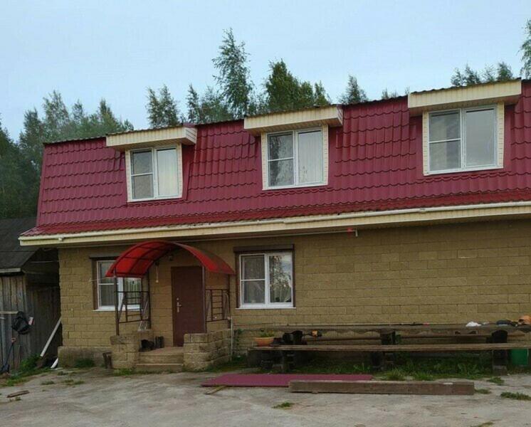 a house with a red roof with a bench in front at Номад in Karakol
