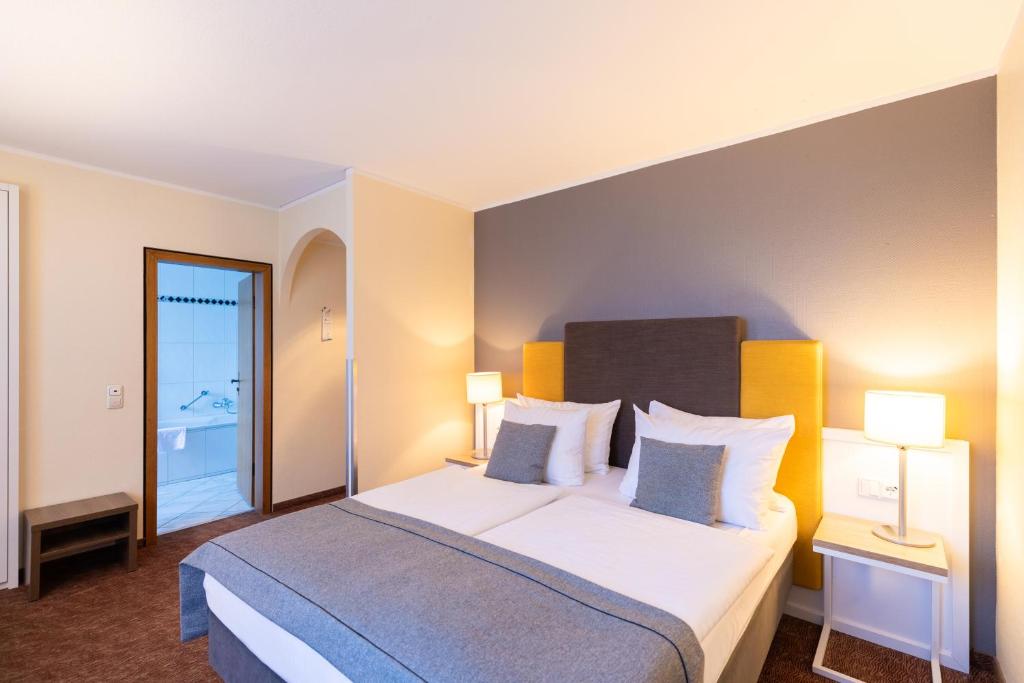 a hotel room with a large bed with two lamps at Select Hotel Silence Garden Köln in Cologne