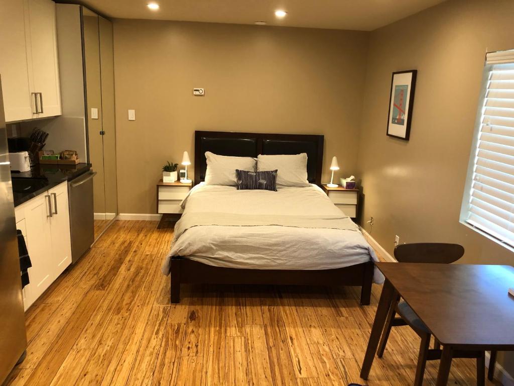 1 dormitorio con 1 cama grande y suelo de madera en Modern studio within easy reach of Tech Giants, en East Palo Alto