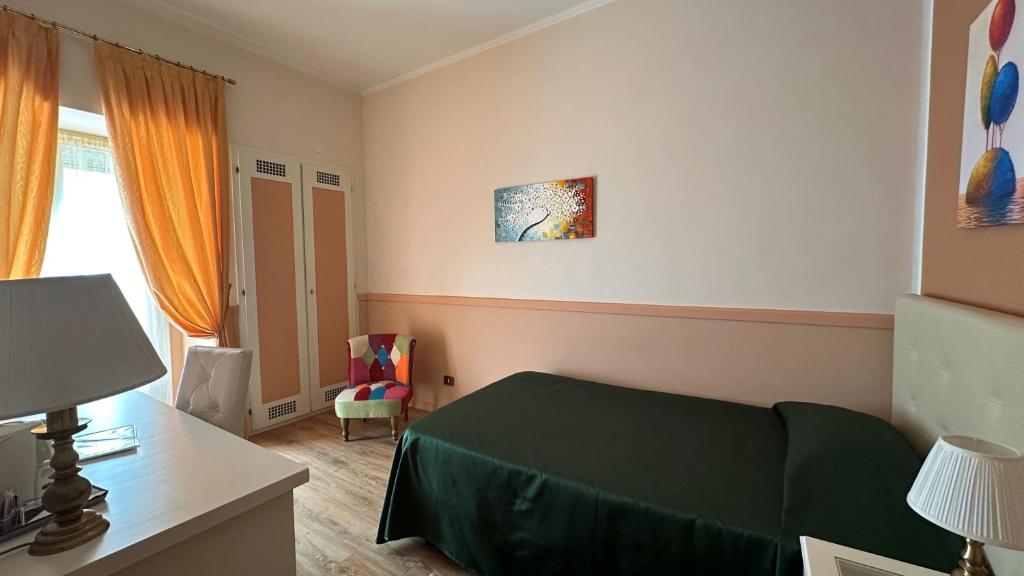a bedroom with a green bed and a desk at Hotel Roma in Bologna