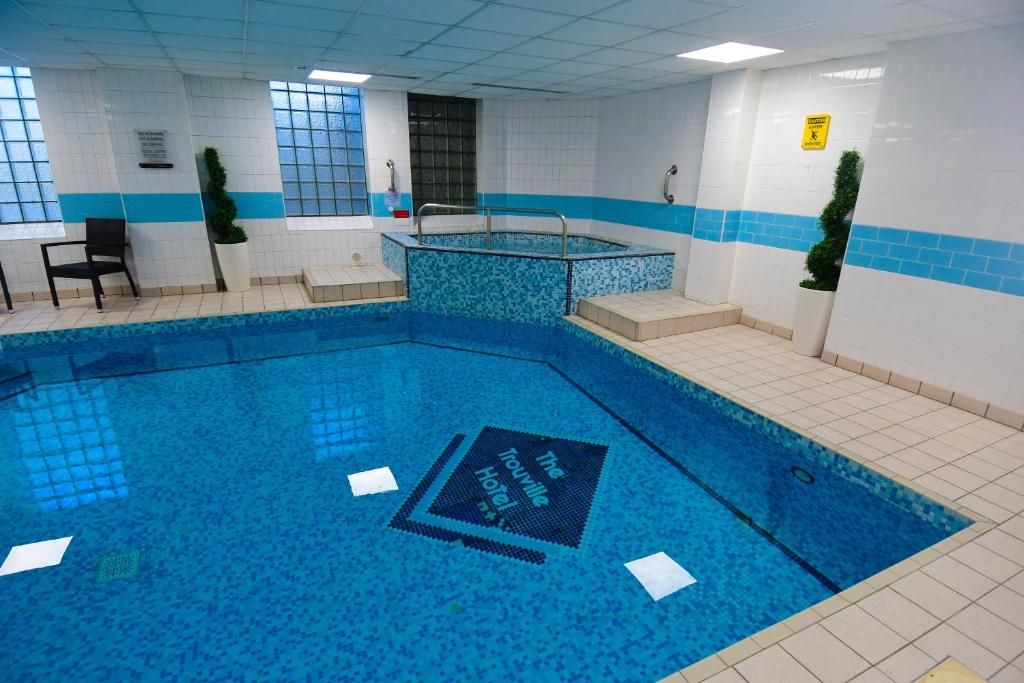 a large swimming pool in a building at The Trouville Bournemouth in Bournemouth
