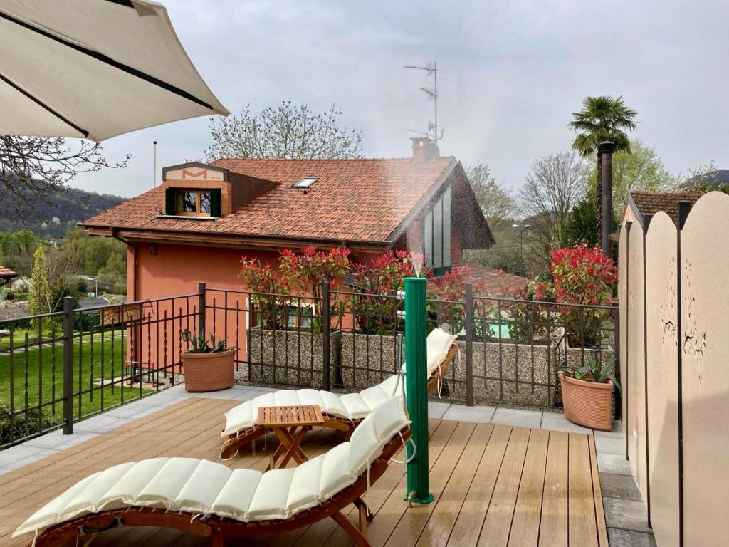 een terras met een groene paal en stoelen en een huis bij Il Gelsomino - Terrace Country House in Pisano