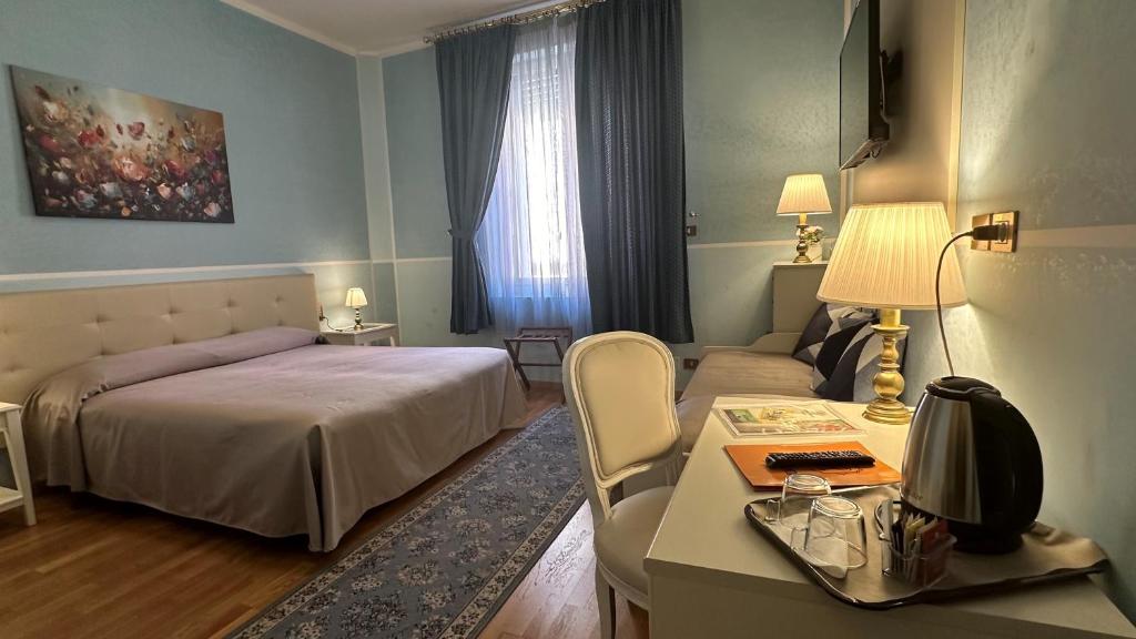 a bedroom with a bed and a desk and a bed and a couch at Hotel Roma in Bologna