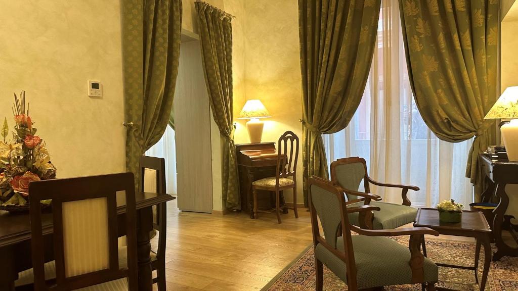 a living room with a table and chairs and a window at Hotel Roma in Bologna