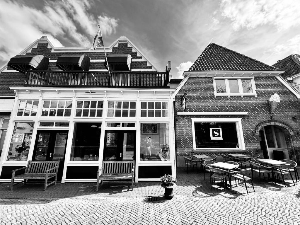 a building with chairs and tables in front of it at Sevenster Delden in Delden