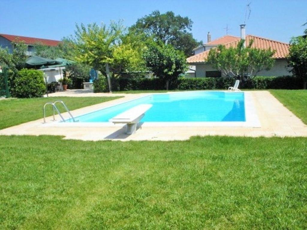 a large swimming pool in the yard of a house at Villa fuer 6 Personen mit Schwimmbad in Mosciano SantʼAngelo