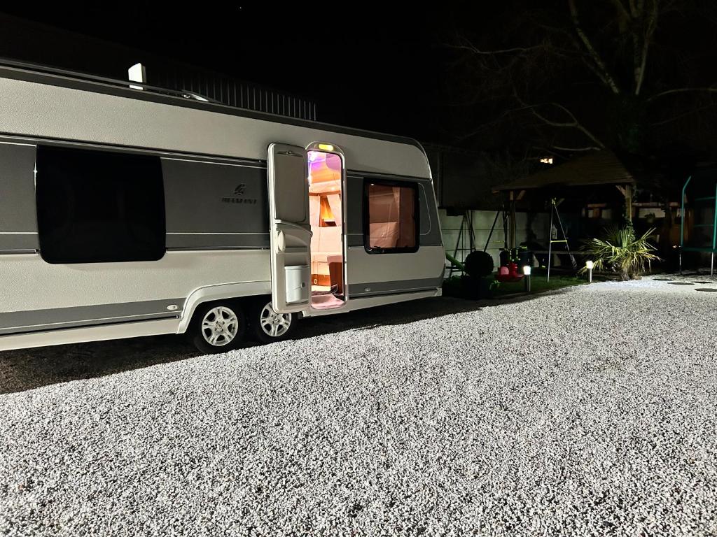 una caravana plateada estacionada en un camino de grava en Terrain de loisirs en plein centre de Lièvin, en Liévin