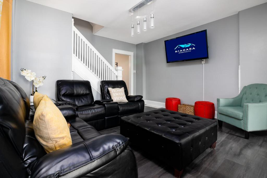 uma sala de estar com mobiliário de couro e uma televisão em The Texas Hold-em Duplex- 3BR Free Parking, Minutes From Falls & Casino em Niagara Falls