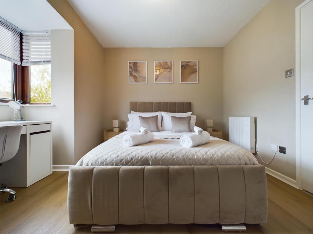 a bedroom with a large bed and a desk at Cosy Modern Apartment Colchester in Colchester