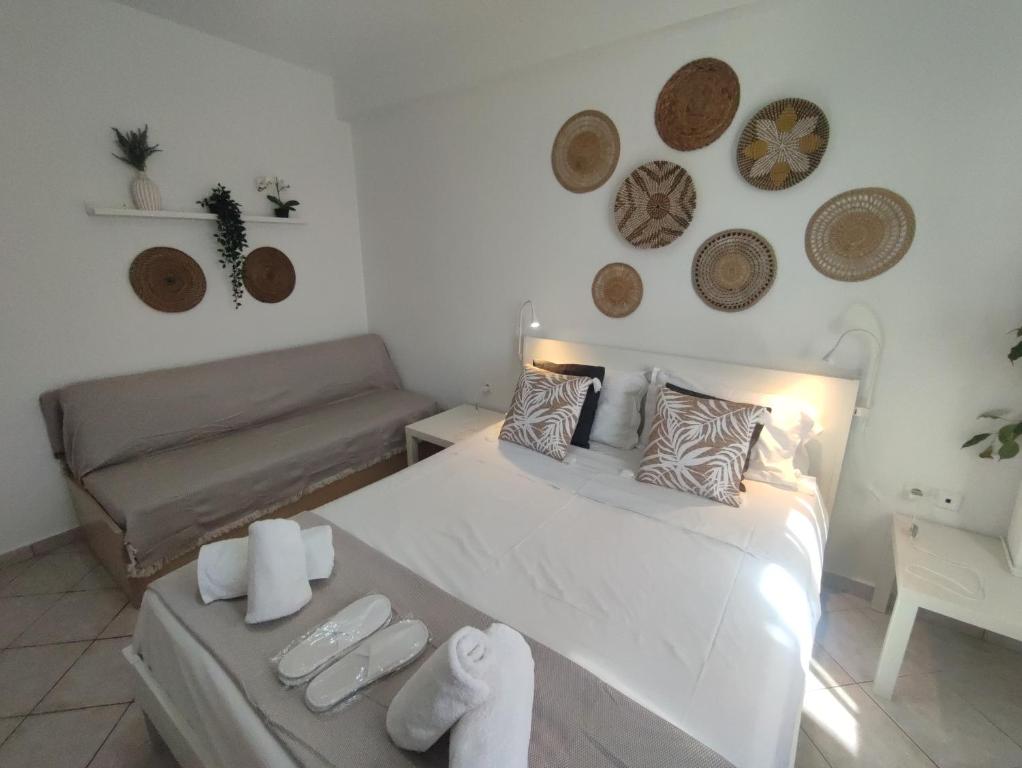 a bedroom with a white bed and a couch at SEAgull apartments in Nea Peramos