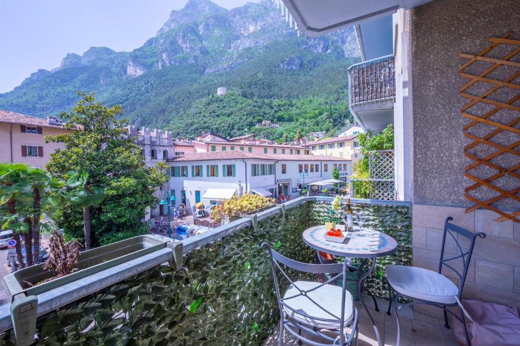 einen Balkon mit einem Tisch, Stühlen und einem Berg in der Unterkunft Riva Dante Apartment in Riva del Garda