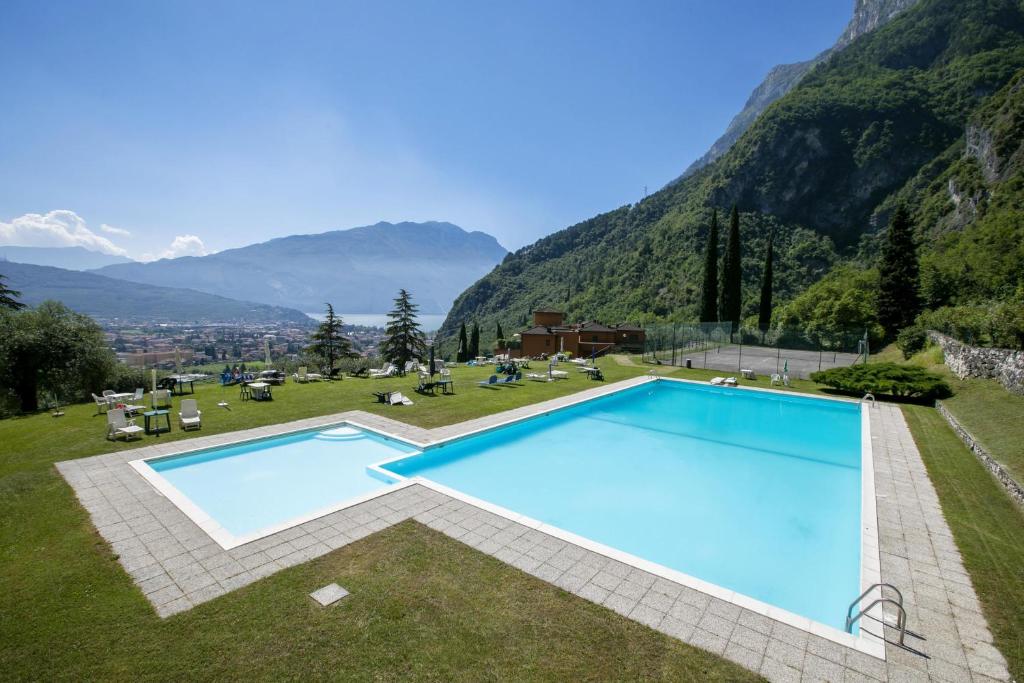 une piscine avec des montagnes en arrière-plan dans l'établissement Lake View Dom-Us Apartment, à Riva del Garda