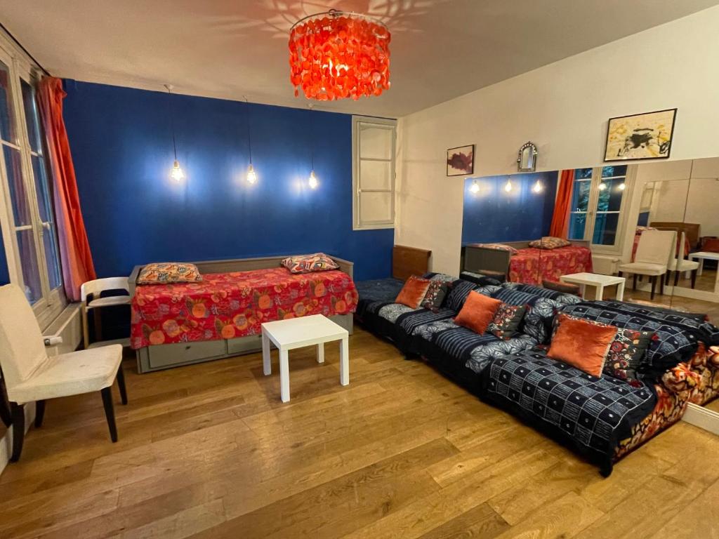 ein Wohnzimmer mit einem Sofa und einem Bett in der Unterkunft Maison stylée avec jardin caché, Vincennes in Vincennes