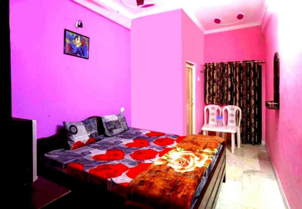 a pink bedroom with a bed with flowers on it at Hotel Parteek Residency Near Amrabati Park - Bypass Road Digha in Digha