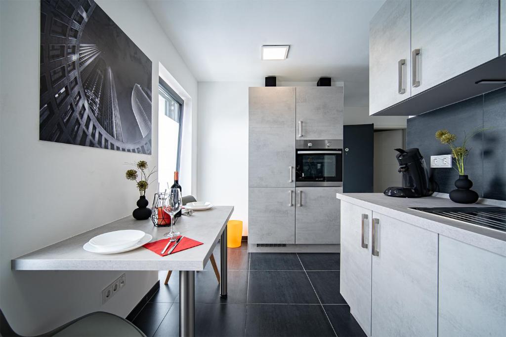 a kitchen with white cabinets and a table with plates on it at Blauer Stein 7a WH03 - Apartment 2 SZ, 5 Betten in Pulheim