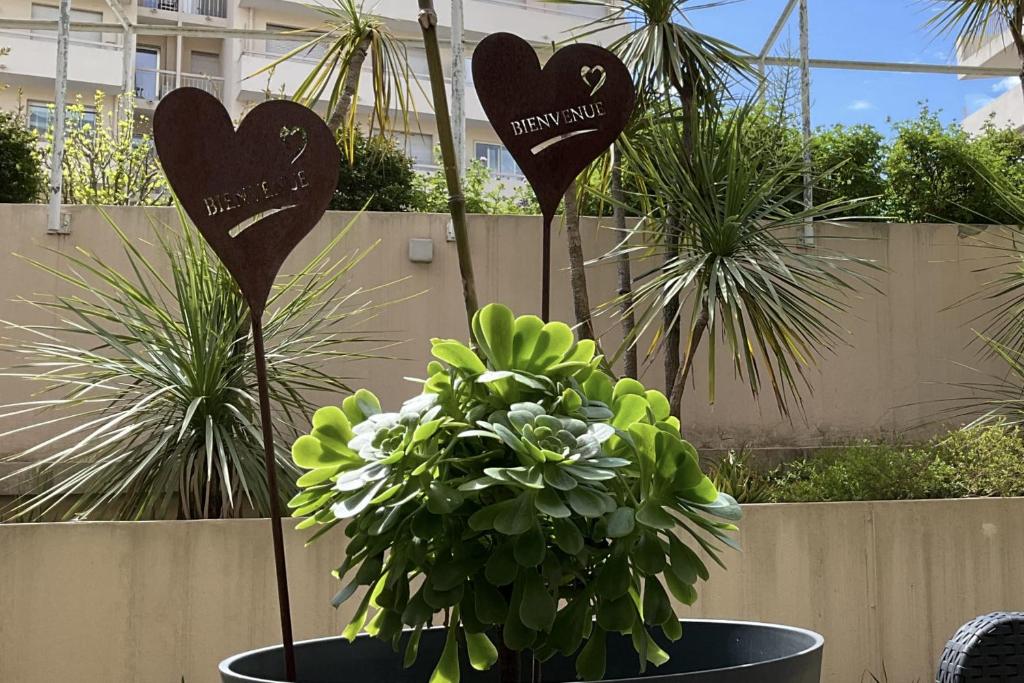 deux signaux cardiaques dans un pot avec une plante dans l'établissement Charming refurbished cocoon with swimming pool, à Cannes