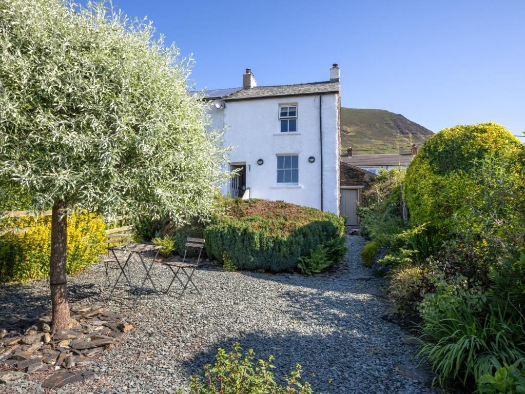 Una casa blanca con un árbol delante. en 2 Bed in Threlkeld SZ082, en Threlkeld