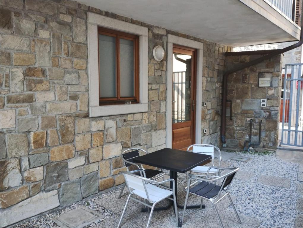 a table and chairs in front of a stone wall at BORGO CONTOVELLO in Trieste