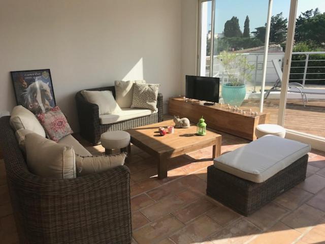 un salon avec deux chaises et une table basse dans l'établissement L'Etrier Camarguais superbe appartement 2 chambres piscine, à Saintes-Maries-de-la-Mer