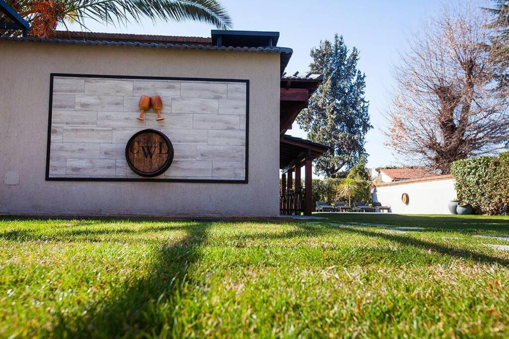 a wall with a clock on the side of a house at Casa Wineland Logde West 4Pax - by Inside in Ciudad Lujan de Cuyo