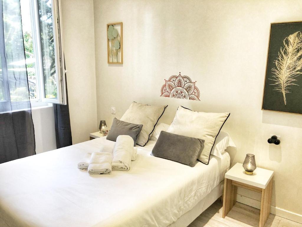 - un lit blanc avec 2 oreillers dans l'établissement Hôtel Ô9 marches, à Rillieux-la-Pape