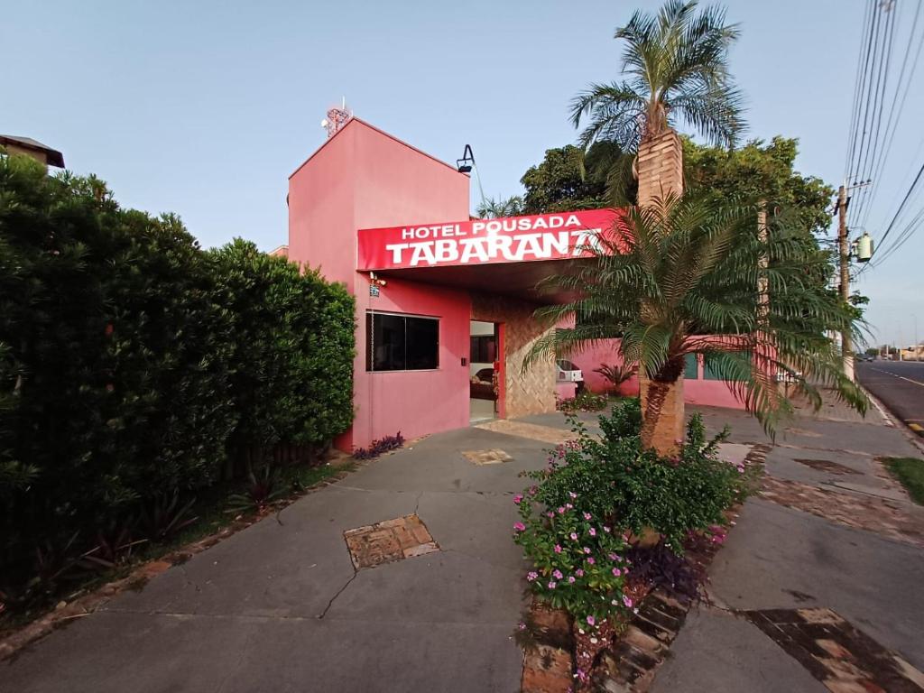 a pink building with a sign for a restaurant at HOTEL TABARANA in Ubarana