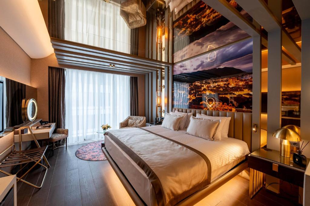 a hotel room with a large bed and a desk at Merit Starlit Hotel & Residences in Budva