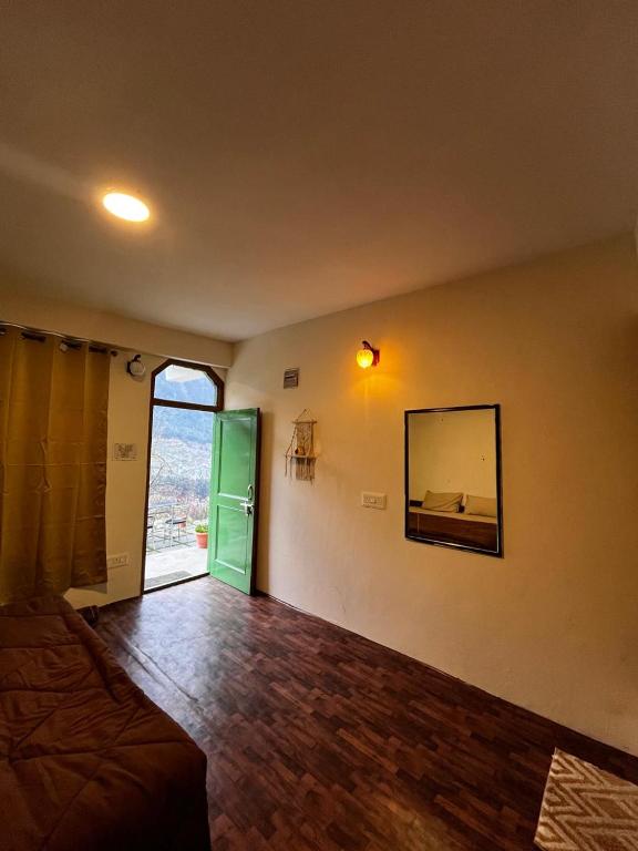 una camera con un letto e uno specchio a parete di Nomadic Den Manali a Manāli