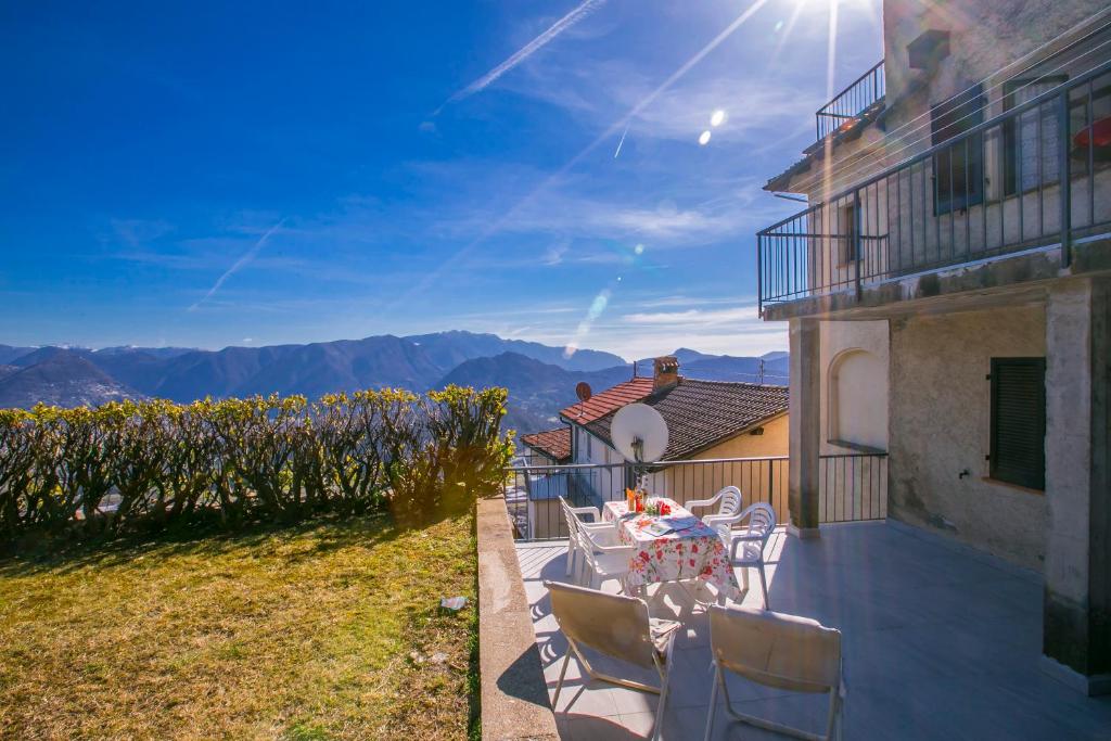 eine Terrasse mit einem Tisch und Stühlen an der Seite eines Gebäudes in der Unterkunft Chalet Cademario - Happy Rentals in Cademario