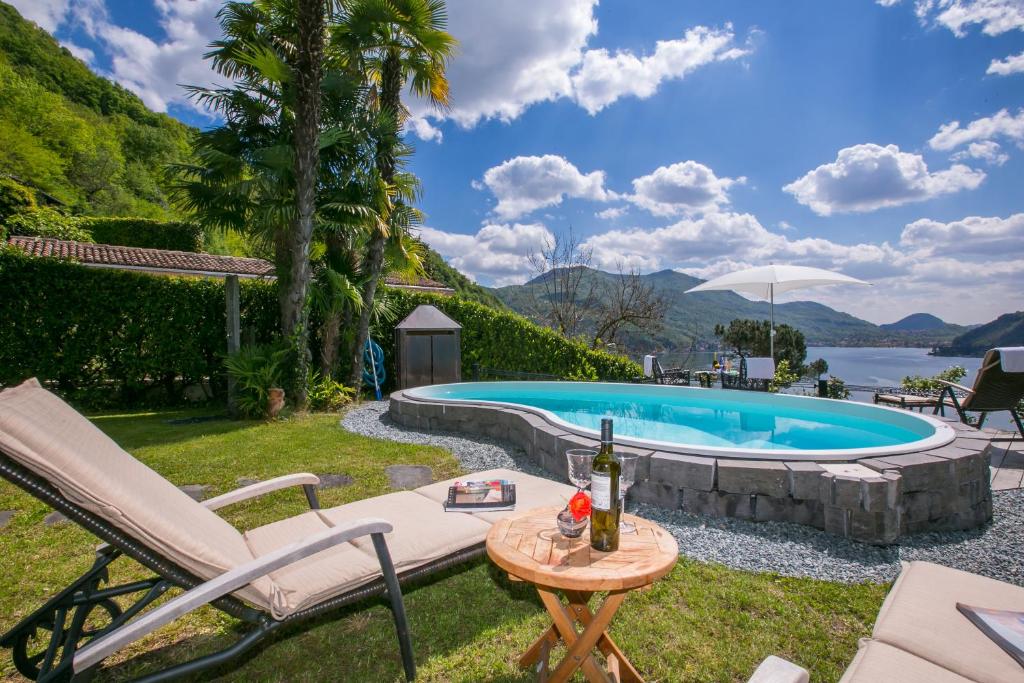 a backyard with a pool and a table with a bottle of wine at Morcote Magic View in Morcote