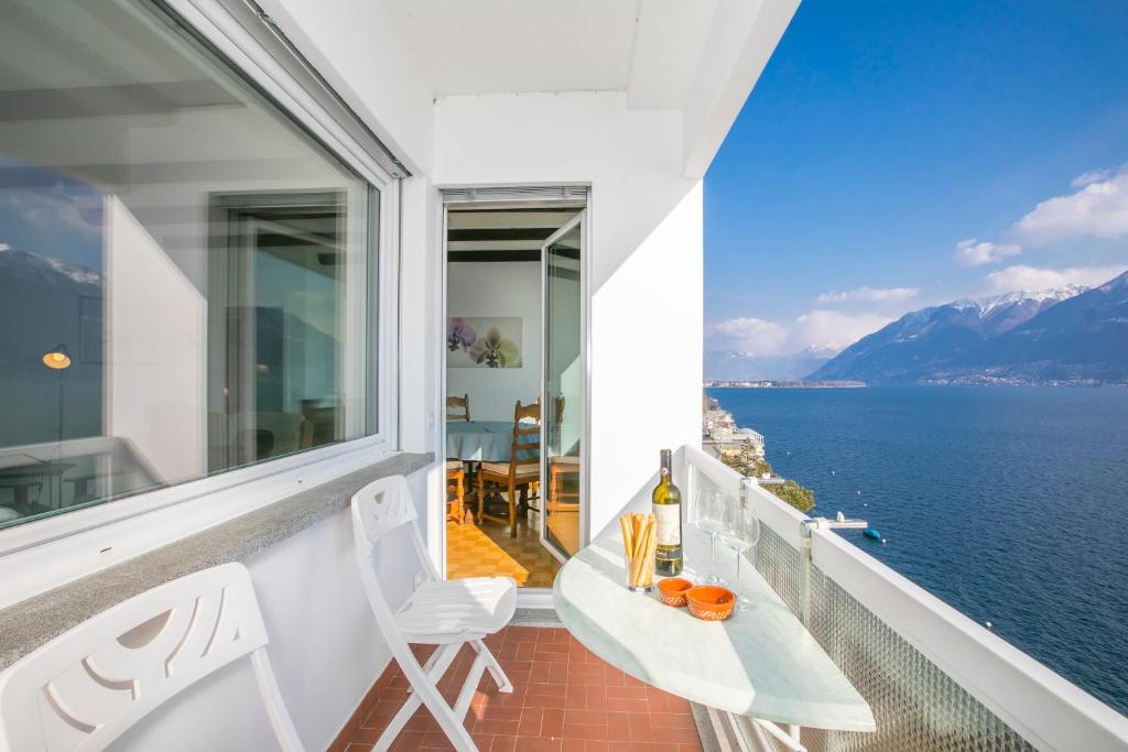 einen Balkon mit Blick auf das Wasser in der Unterkunft Bellevue Apartment - Happy Rentals in Ronco sopra Ascona