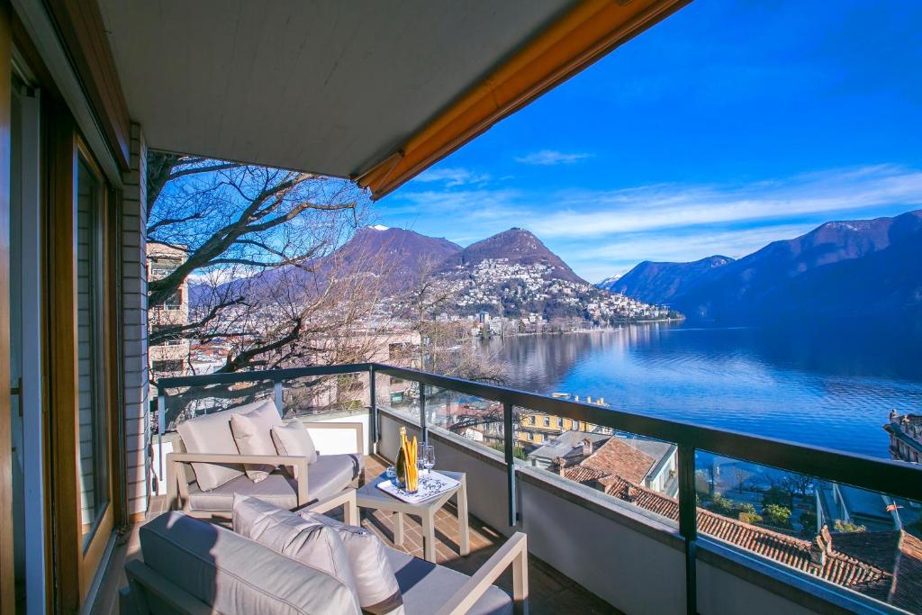 ルガノにあるLugano Motta - Happy Rentalsの湖と山々の景色を望むバルコニー