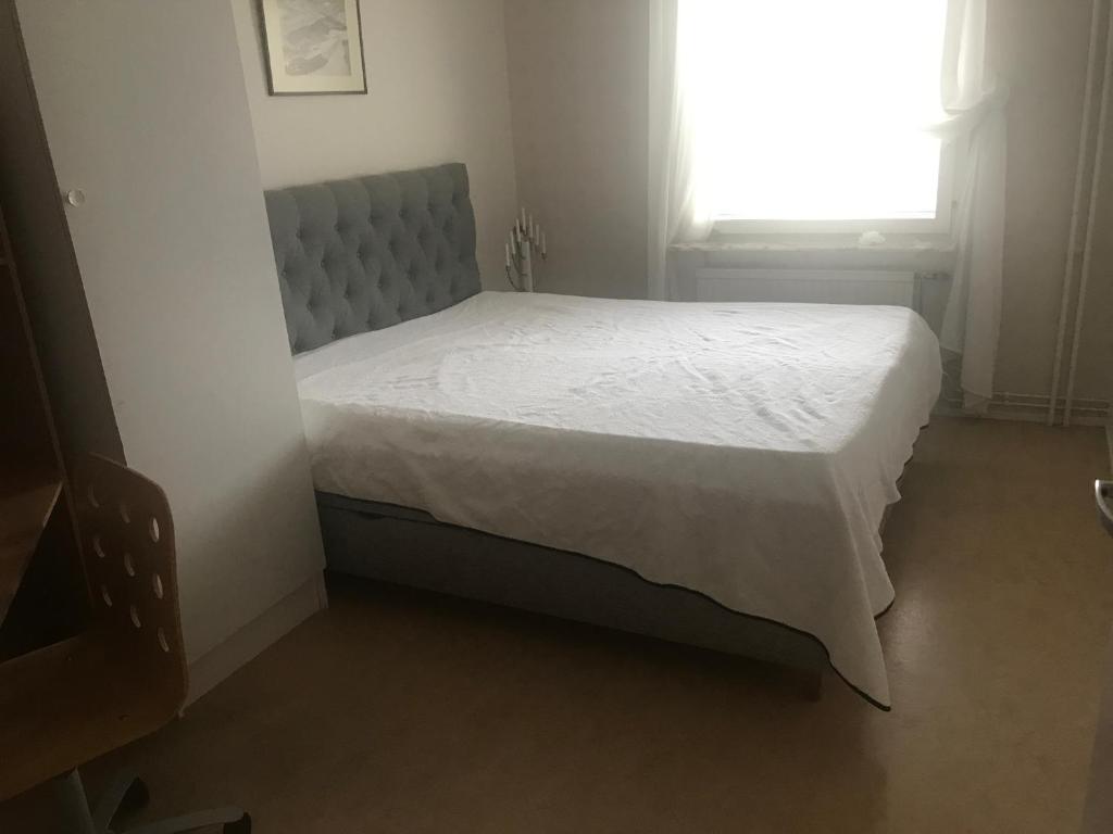 een bed in een kleine kamer met een raam bij 2 sovrum i en del av lägenheten in Stockholm