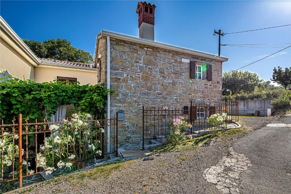 une maison en pierre avec une porte en face dans l'établissement Istrian Stone House With Hot Tub - Happy Rentals, à Gračišče