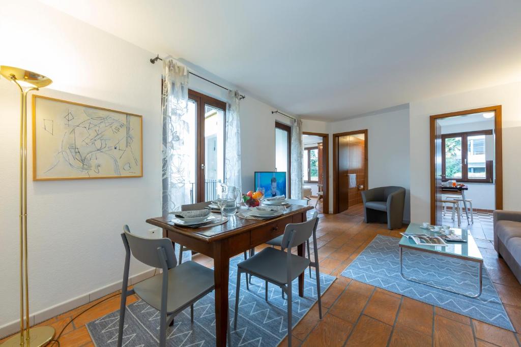 a living room with a table and chairs and a couch at Casa Chiara - Happy Rentals in Locarno